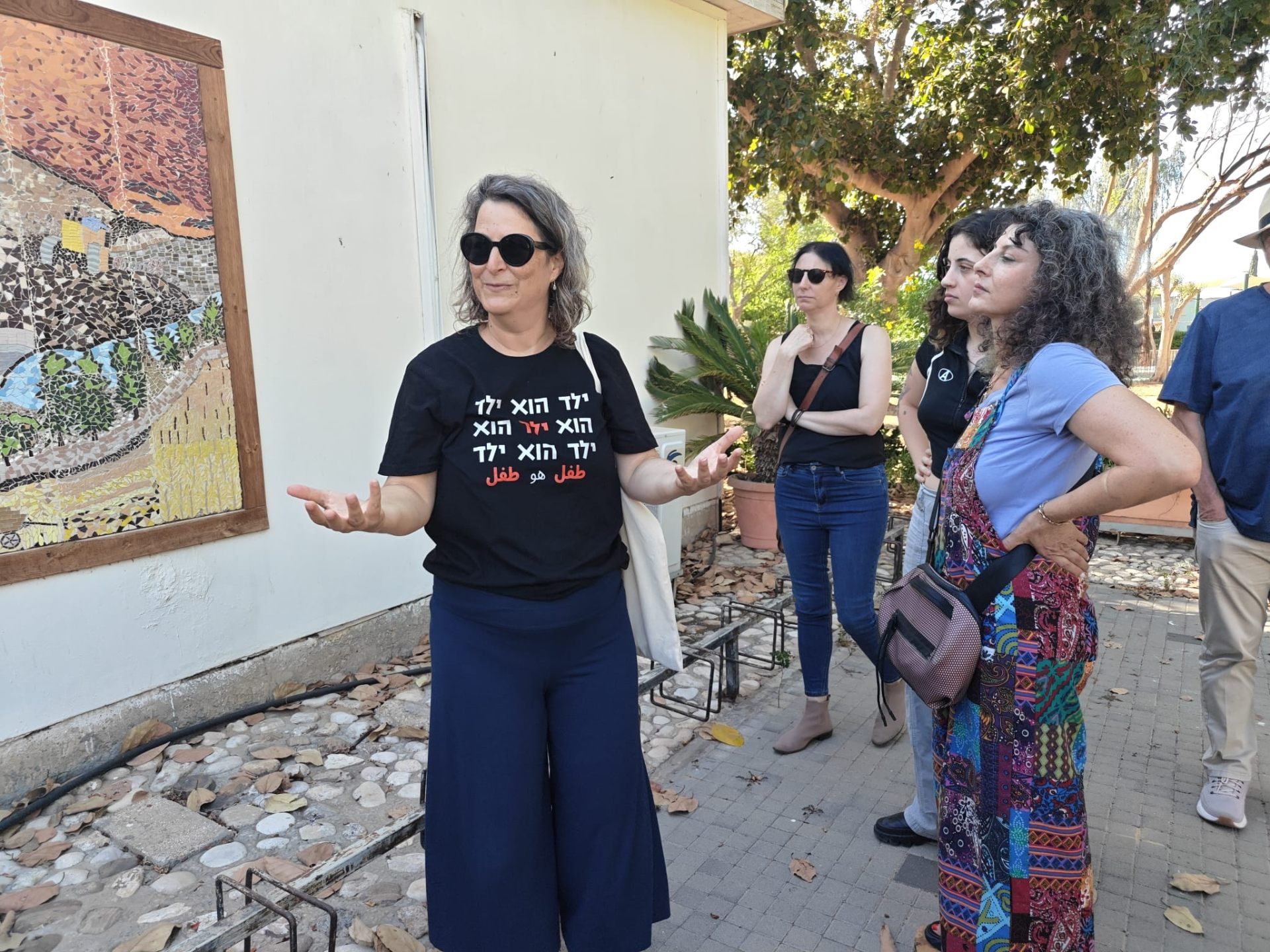 אילה מצגר מספרת את סיפור הקהילה לקבוצת מבקרים